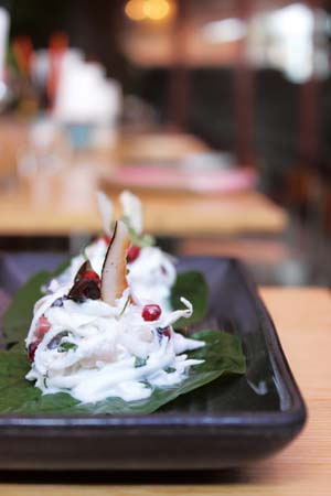 Lime cured hapuka, coconut, pomegrante, chilli on betel leaf